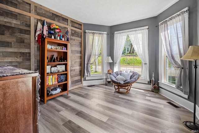 47 E Center St, Williamsport, IN 47993 - living area with baseboards, wood walls, healthy amount of natural light, and wood finished floors
