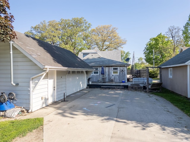 47 E Center St, Williamsport, IN 47993 - back of property featuring an outbuilding, a wooden deck, concrete driveway, and a garage