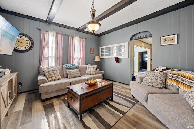 47 E Center St, Williamsport, IN 47993 - living room featuring light wood-type flooring, beam ceiling, and wood walls