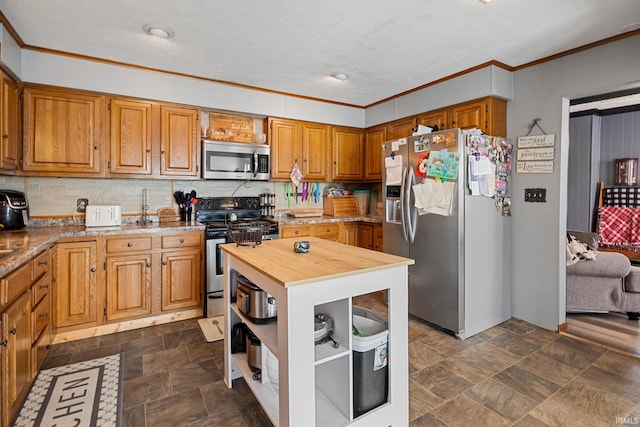 47 E Center St, Williamsport, IN 47993 - kitchen featuring stainless steel appliances, butcher block counters, ornamental molding, tasteful backsplash, and brown cabinets