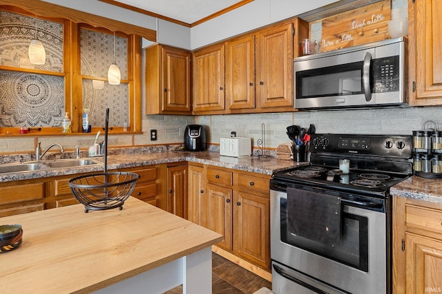 47 E Center St, Williamsport, IN 47993 - kitchen with appliances with stainless steel finishes, ornamental molding, backsplash, brown cabinets, and a sink