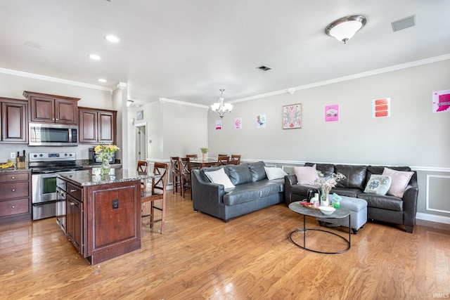 living area with crown molding, a chandelier, light wood finished floors, wainscoting, and recessed lighting