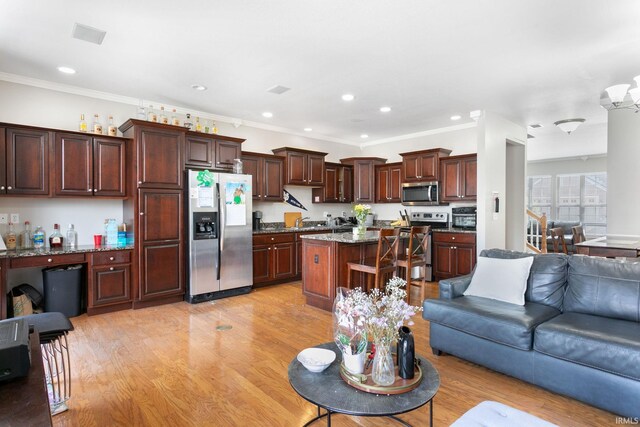 living area featuring light wood-type flooring, recessed lighting, and crown molding