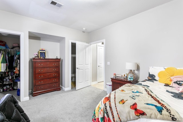 bedroom featuring carpet flooring, a closet, a walk in closet, and baseboards