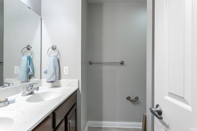 bathroom with double vanity and baseboards