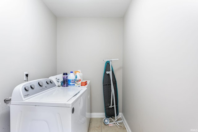 laundry room featuring washing machine and dryer, light tile patterned floors, and baseboards