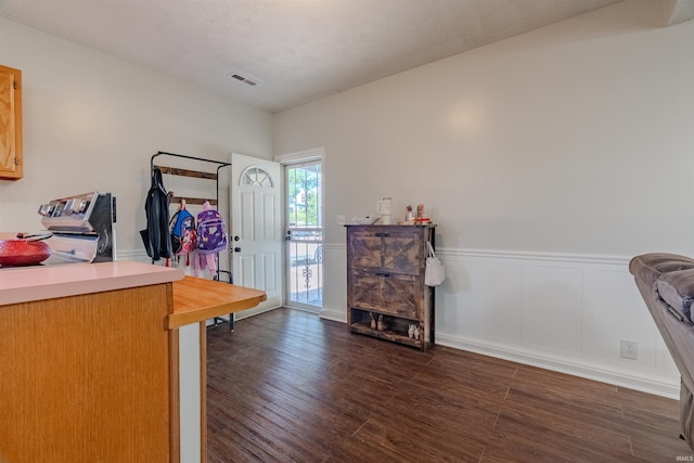 office space with dark wood finished floors and a wainscoted wall
