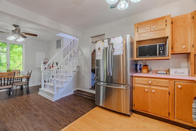kitchen with freestanding refrigerator, ceiling fan, light wood-style flooring, and light countertops