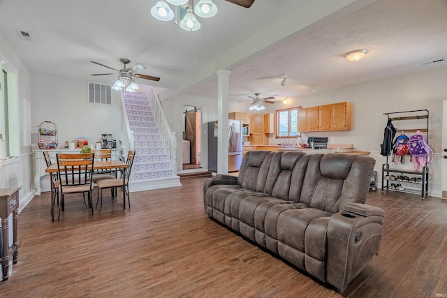 living area with a ceiling fan, stairs, and wood finished floors