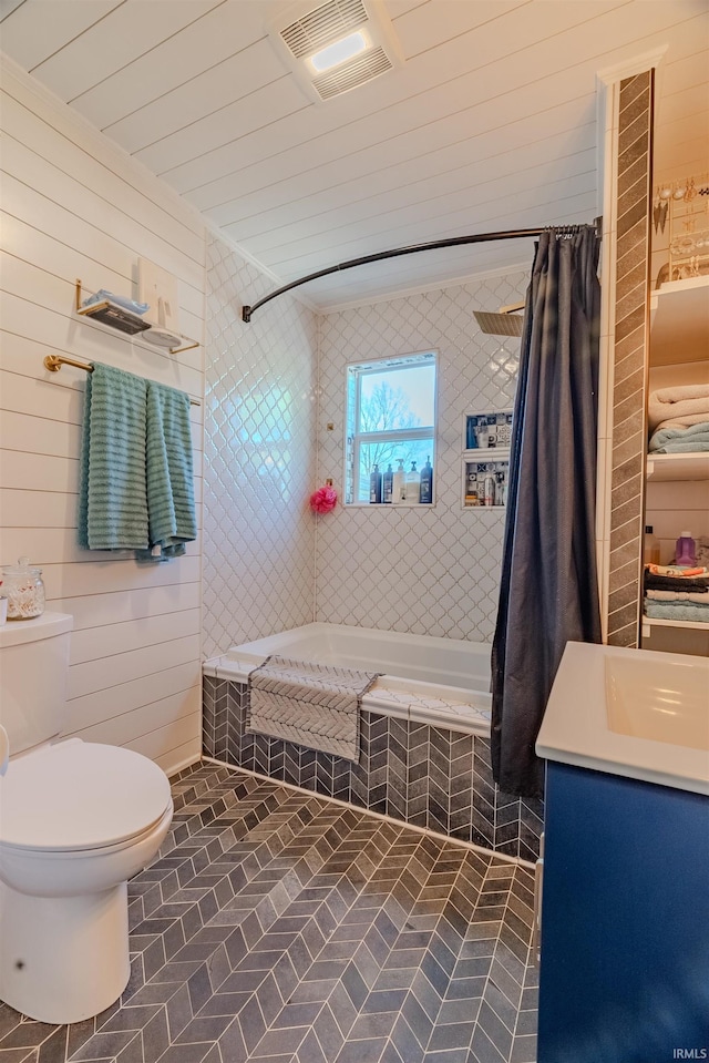 full bathroom with tiled shower / bath, toilet, vanity, brick patterned flooring, and wood walls
