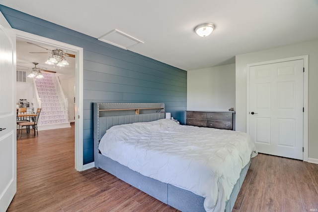bedroom featuring wood finished floors, baseboards, and attic access