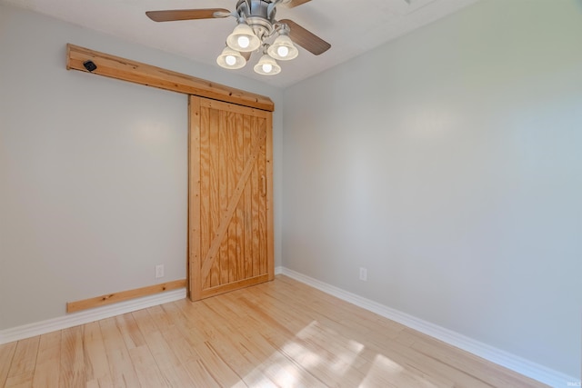 unfurnished room with ceiling fan, wood finished floors, and baseboards