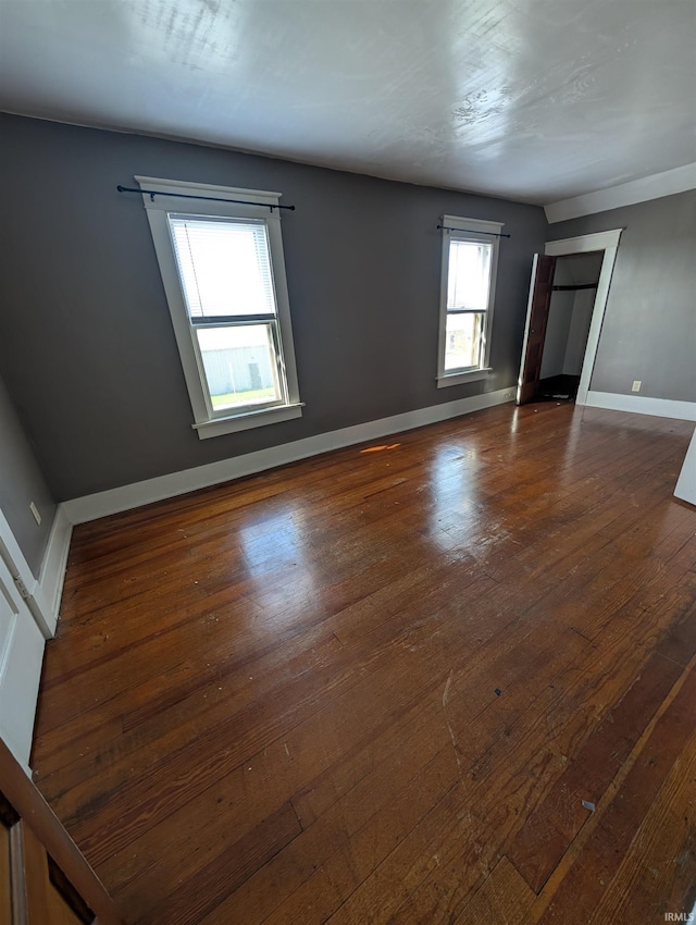 empty room featuring dark wood-style floors and baseboards