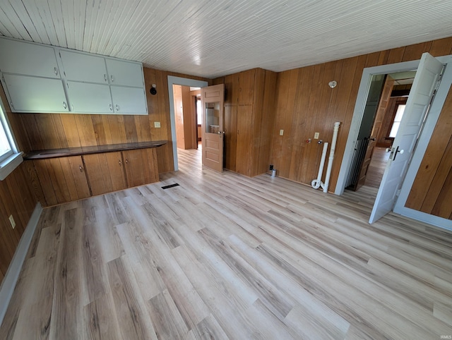 unfurnished dining area featuring wooden walls and light wood-style floors
