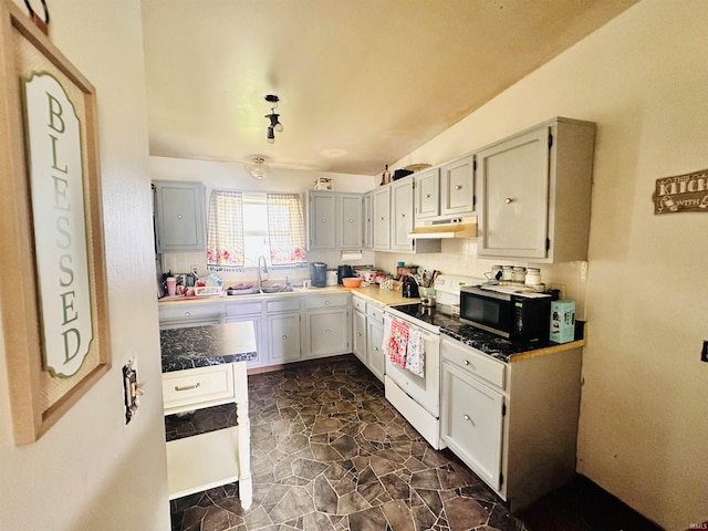 2796 Alexandria Ct, Lafayette, IN 47909 - kitchen featuring under cabinet range hood, white range with electric stovetop, a sink, dark countertops, and dark stone finish flooring
