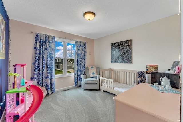 bedroom featuring carpet floors, baseboards, and a textured ceiling