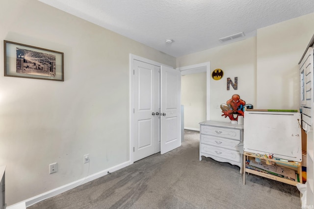 carpeted bedroom featuring baseboards and a textured ceiling