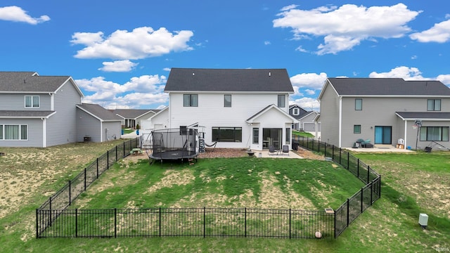 rear view of house featuring a trampoline, a sunroom, a residential view, and a patio area