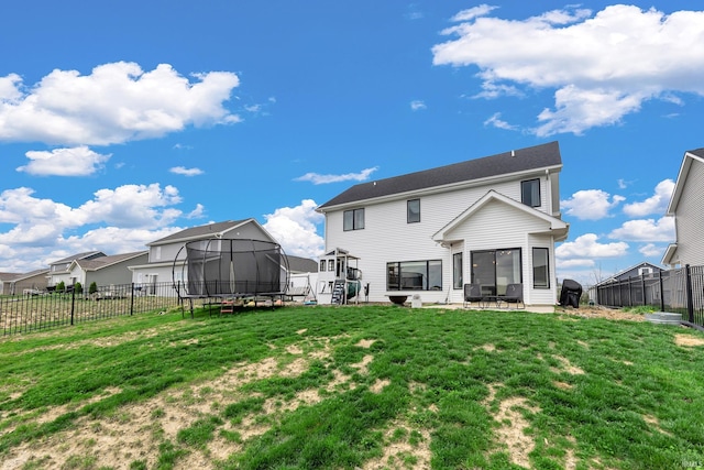 back of property with a trampoline and a patio