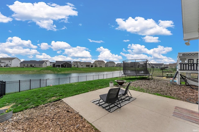 view of patio with a trampoline, a residential view, and a water view