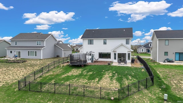 back of house featuring a trampoline, a sunroom, a residential view, and a patio