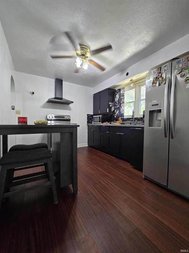 304 N Main St, South Whitley, IN 46787 - kitchen featuring wall chimney exhaust hood, stainless steel appliances, a ceiling fan, dark wood-style flooring, and a sink