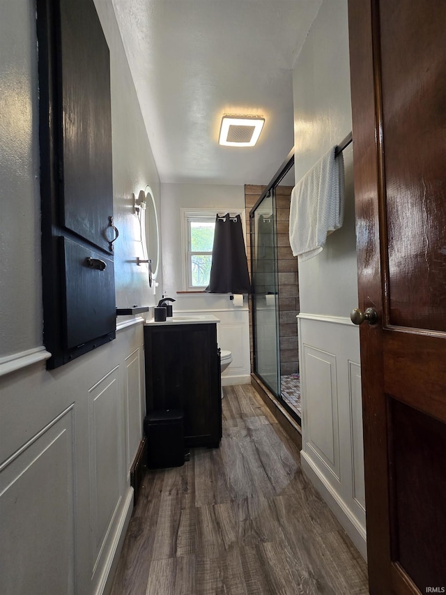 304 N Main St, South Whitley, IN 46787 - bathroom featuring toilet, a shower stall, wood finished floors, and vanity