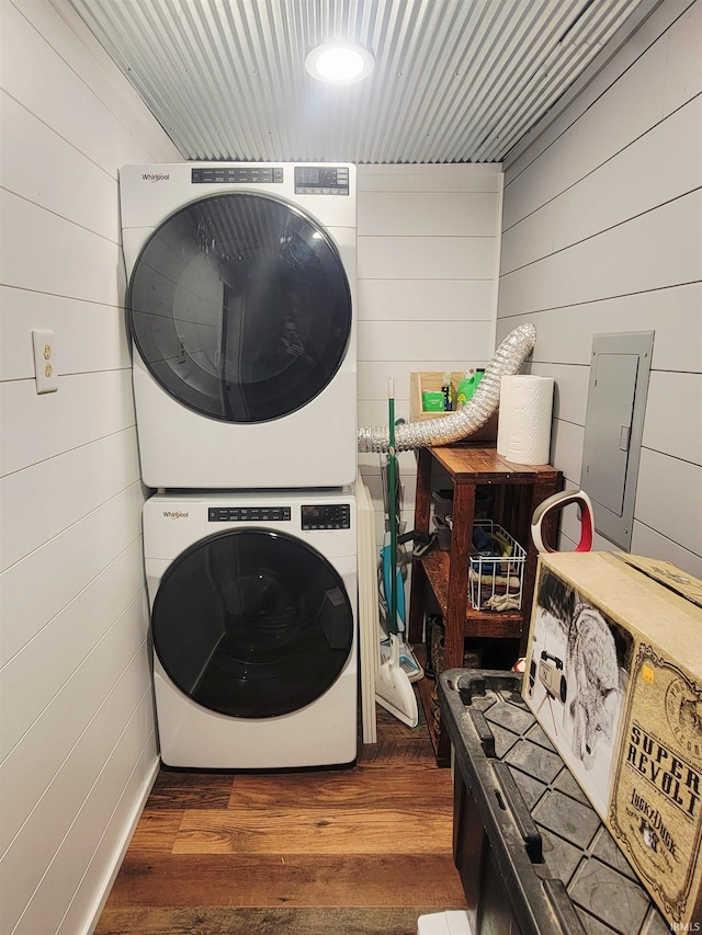 109 N Martin St, Ligonier, IN 46767 - laundry area featuring stacked washer and clothes dryer, wooden walls, wood finished floors, and electric panel