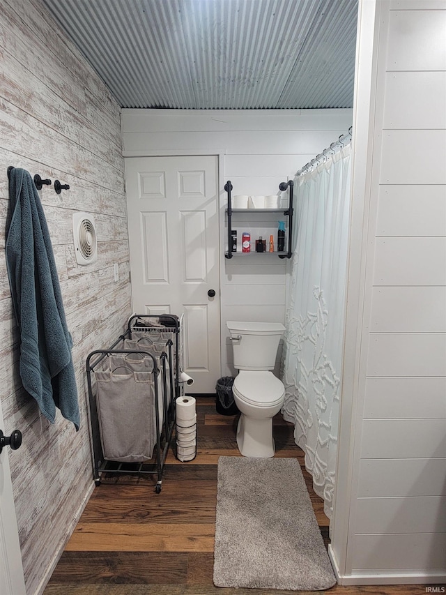 109 N Martin St, Ligonier, IN 46767 - bathroom with wood walls, toilet, wood finished floors, and a shower with curtain