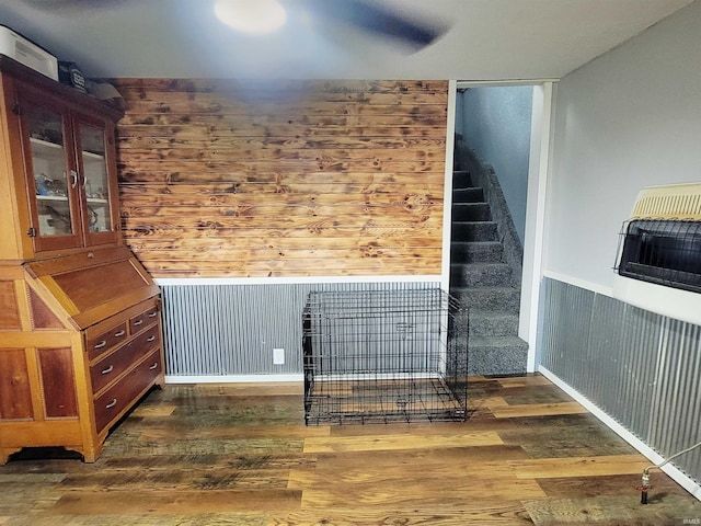 109 N Martin St, Ligonier, IN 46767 - unfurnished living room featuring wood finished floors, heating unit, wood walls, and stairway