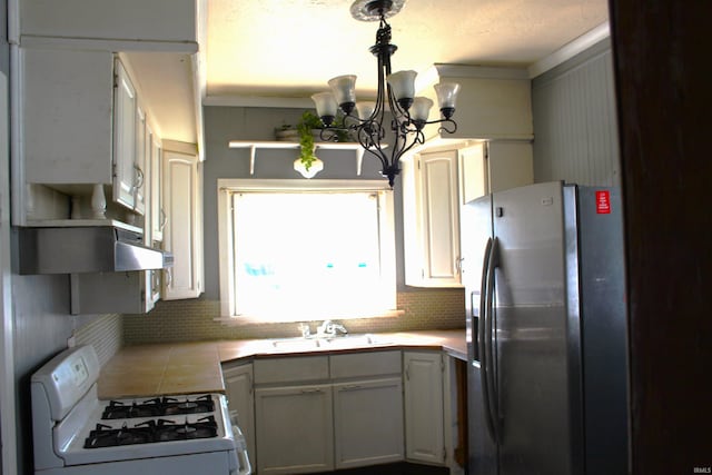 404 S Peters St, Garrett, IN 46738 - kitchen with stainless steel refrigerator with ice dispenser, white range with gas cooktop, a sink, a chandelier, and tile countertops