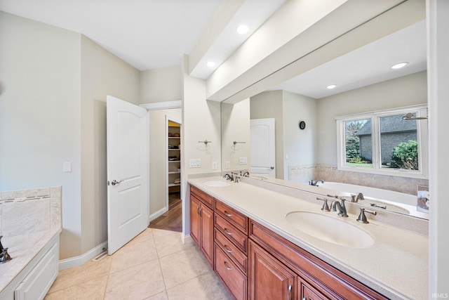 51025 Bellcrest Cir, Granger, IN 46530 - bathroom featuring a garden tub, double vanity, tile patterned floors, recessed lighting, and baseboards