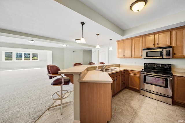 51025 Bellcrest Cir, Granger, IN 46530 - kitchen featuring appliances with stainless steel finishes, a sink, a kitchen bar, a peninsula, and light countertops