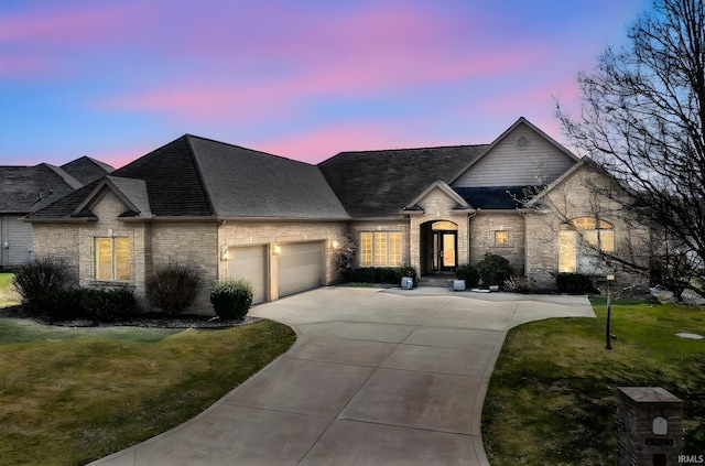51025 Bellcrest Cir, Granger, IN 46530 - french country home with a garage, driveway, roof with shingles, a front yard, and brick siding