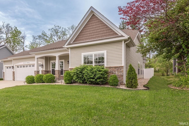 craftsman house with an attached garage, a front lawn, stone siding, concrete driveway, and a porch
