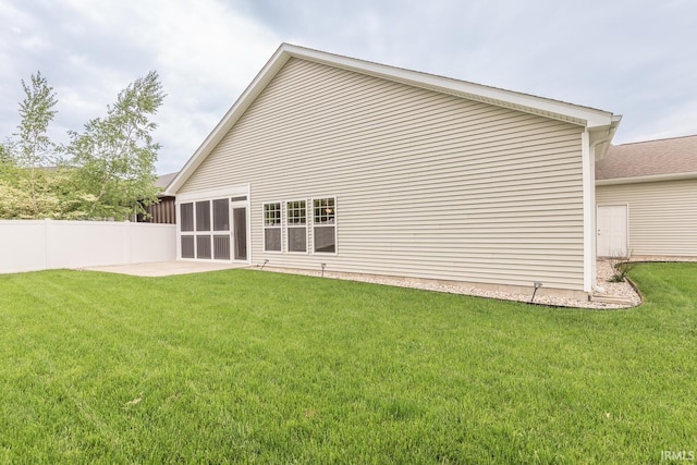 rear view of property featuring a sunroom and a patio area