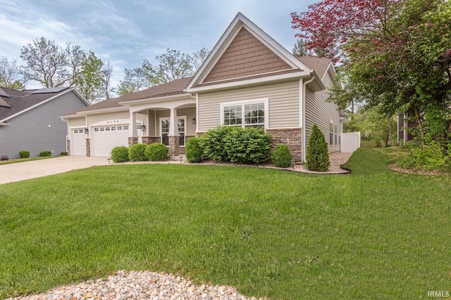 craftsman inspired home with an attached garage, a front lawn, concrete driveway, and stone siding