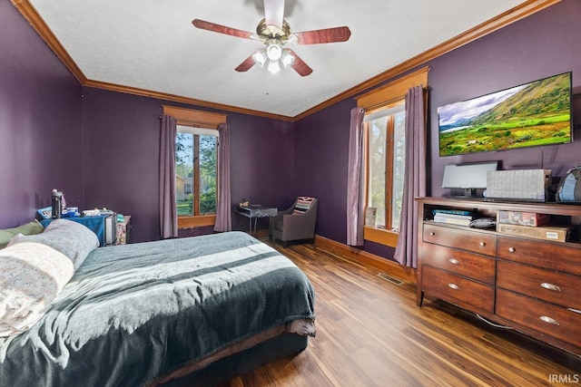 bedroom with crown molding, wood finished floors, ceiling fan, and baseboards