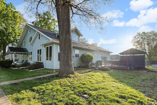 view of side of property featuring a yard and a deck