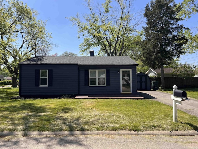 2211 E 19th St, Muncie, IN 47302 - view of front of home with a storage shed, an outdoor structure, and a shingled roof