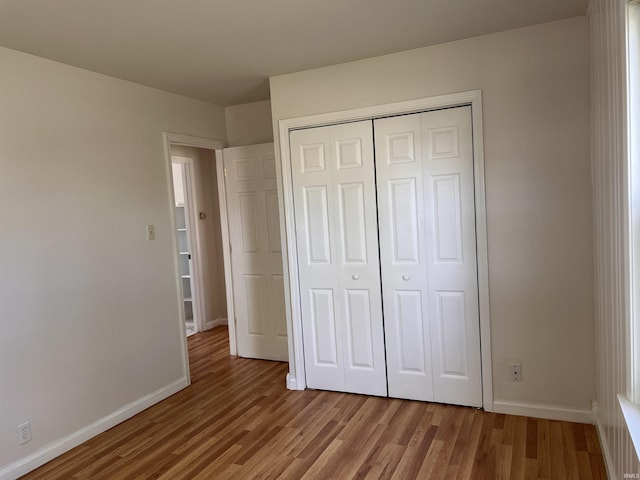 2211 E 19th St, Muncie, IN 47302 - unfurnished bedroom with wood finished floors, baseboards, and a closet