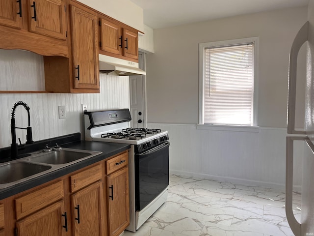 2211 E 19th St, Muncie, IN 47302 - kitchen featuring range with gas cooktop, under cabinet range hood, light marble finish floors, a sink, and dark countertops