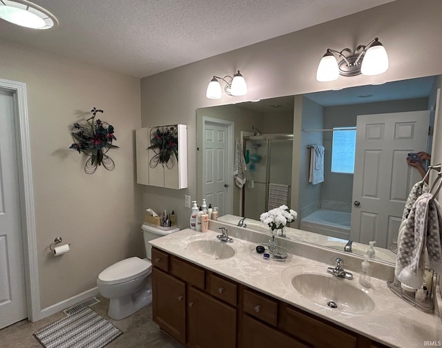 full bath with a shower stall, toilet, a bath, double vanity, and a textured ceiling