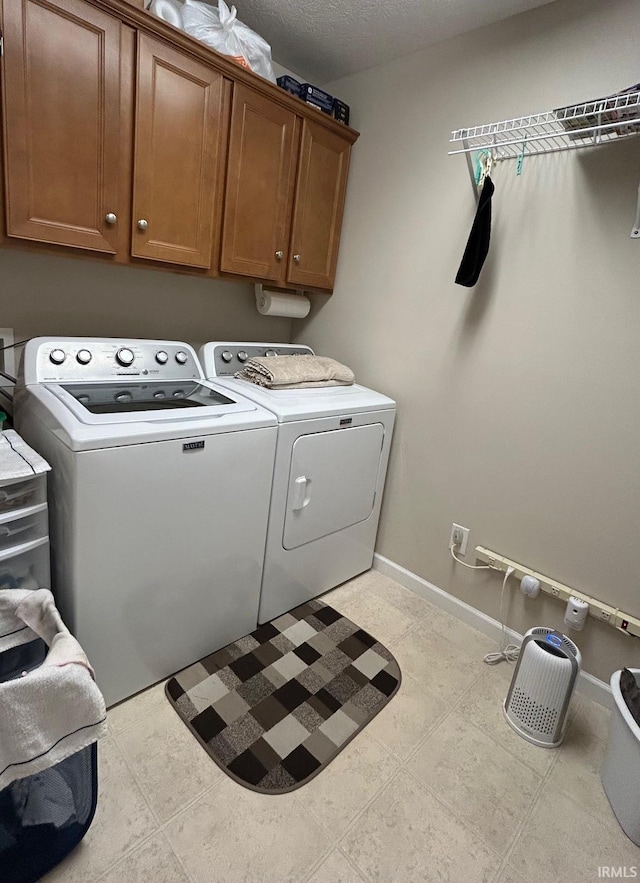 laundry room with cabinet space, independent washer and dryer, and baseboards