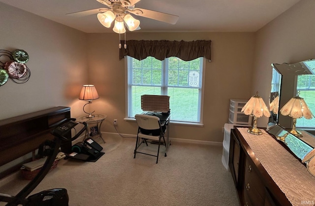 carpeted home office featuring baseboards and ceiling fan