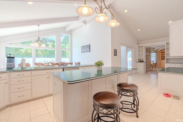 119 Highland Dr, Wabash, IN 46992 - kitchen featuring light tile patterned floors, a kitchen island, a chandelier, white cabinetry, and beam ceiling