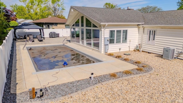 119 Highland Dr, Wabash, IN 46992 - rear view of house featuring central air condition unit, a gazebo, a shingled roof, a fenced backyard, and a patio area