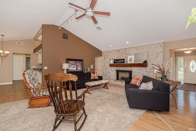 5002 Buffalo Ct, Fort Wayne, IN 46804 - living room with wood finished floors, vaulted ceiling, ceiling fan, a chandelier, and a fireplace