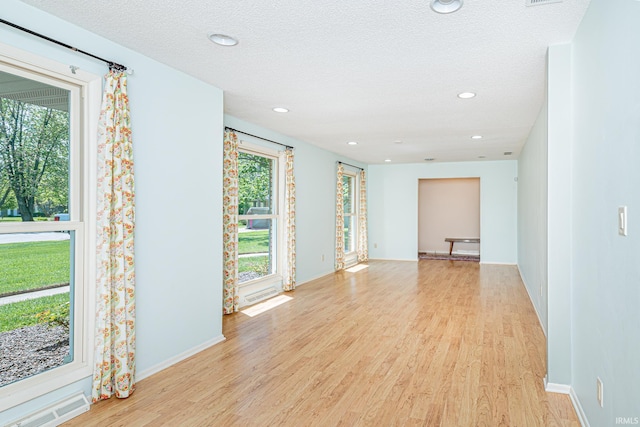 5002 Buffalo Ct, Fort Wayne, IN 46804 - empty room with light wood-type flooring, healthy amount of natural light, recessed lighting, baseboards, and a textured ceiling