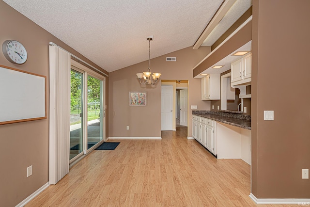 5002 Buffalo Ct, Fort Wayne, IN 46804 - kitchen featuring light wood-type flooring, dark countertops, a chandelier, a textured ceiling, and lofted ceiling